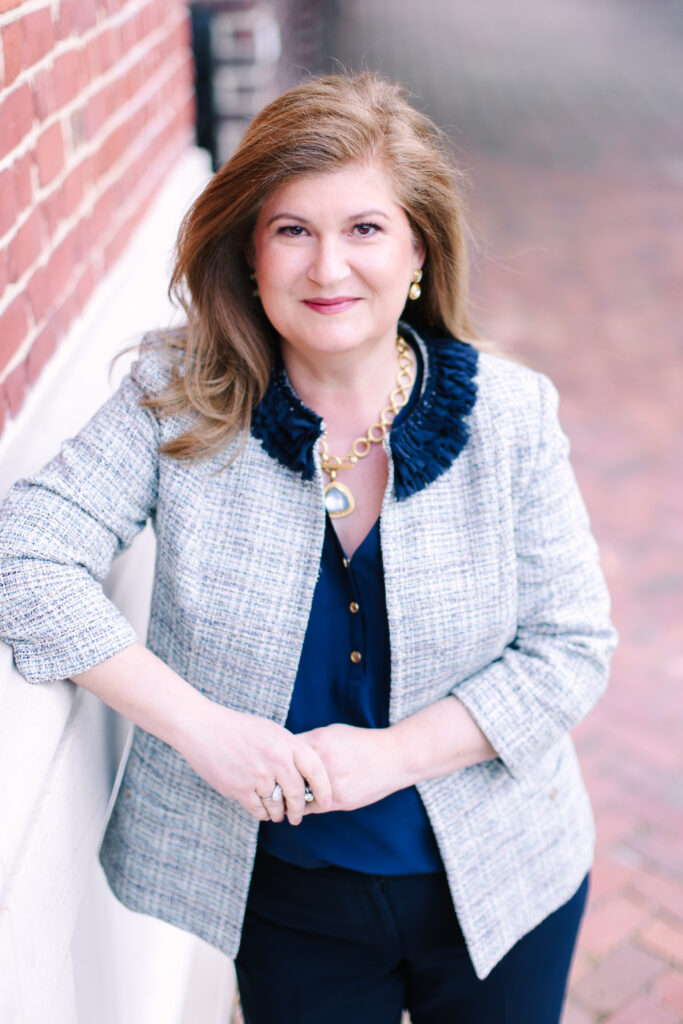 Woman leaning against a red brick wall