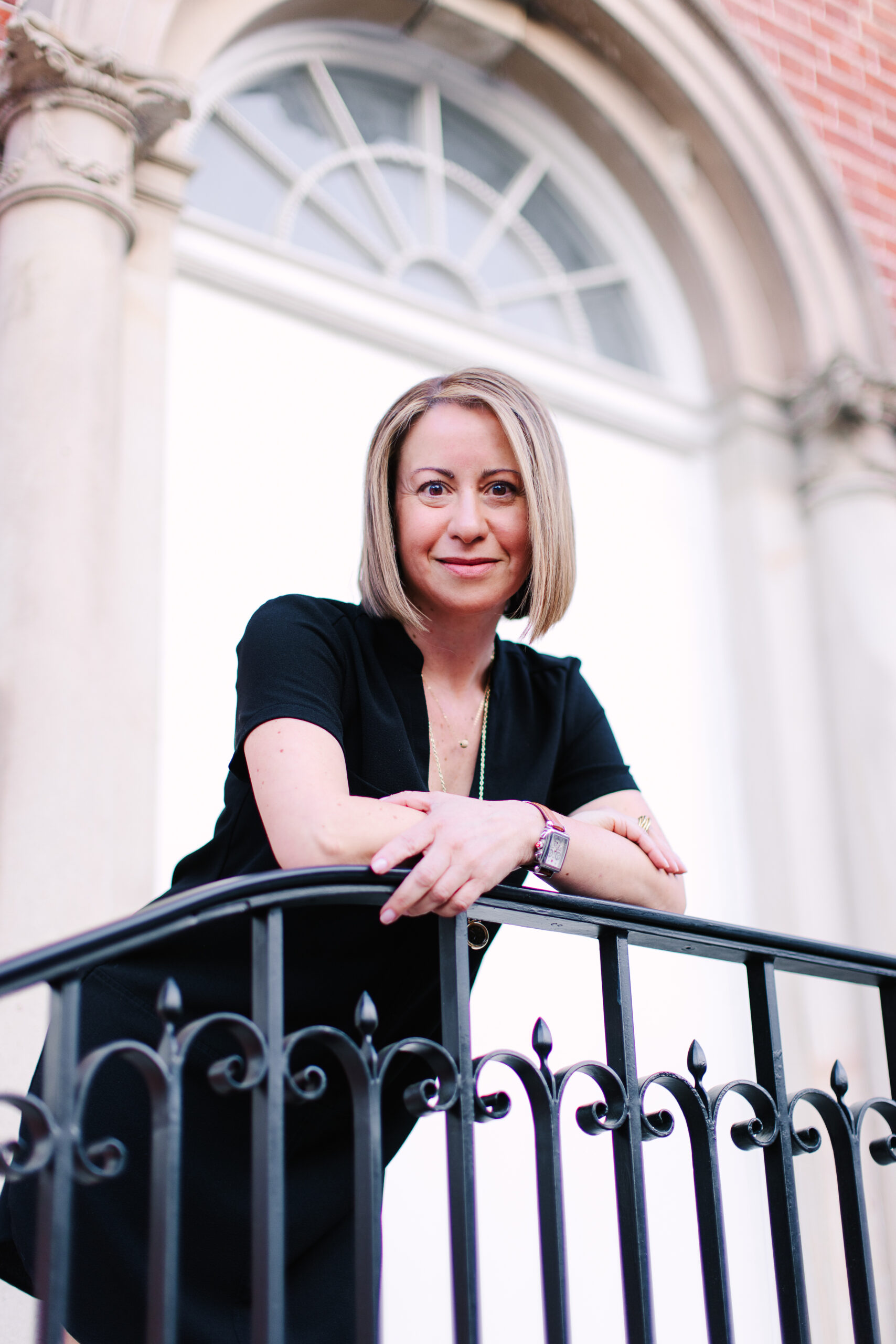 Woman leaning on black railing