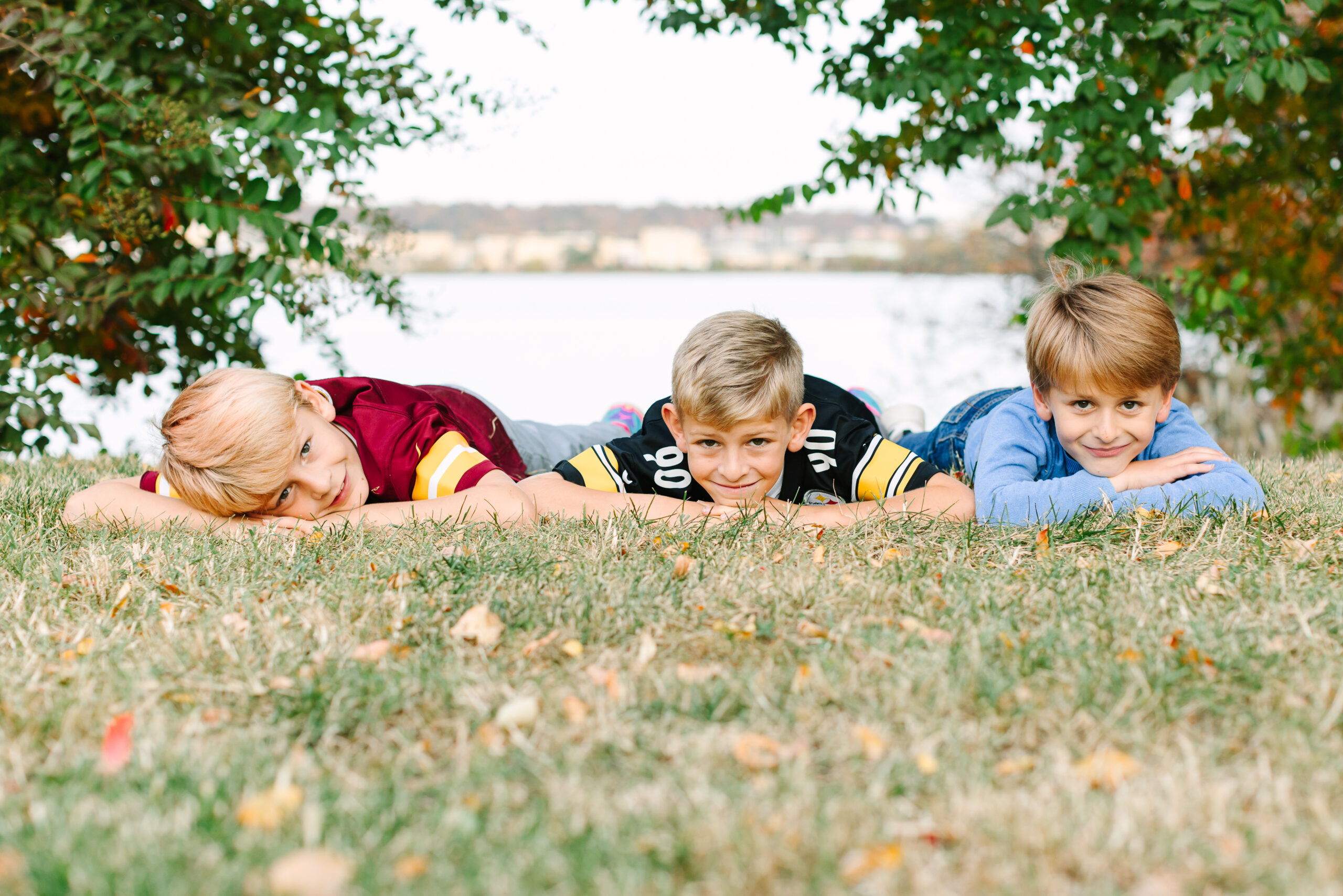 Three boys, lying in the grass