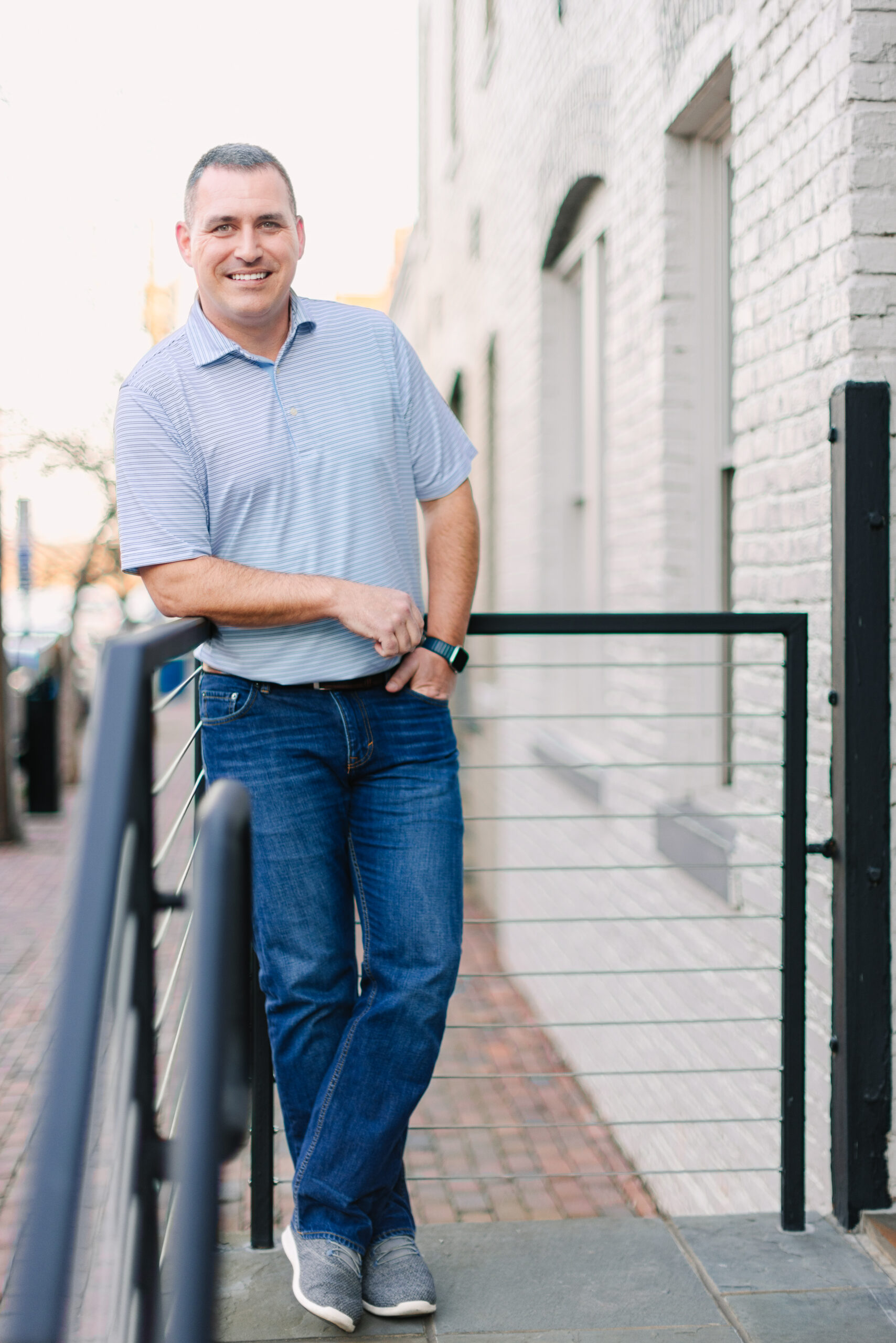 Man stood next to white brick building