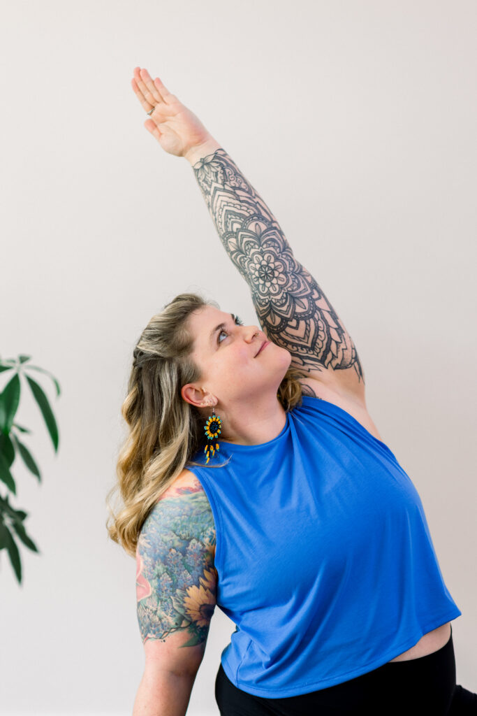 Yoga instructor with elaborate body tattoos in a pose.