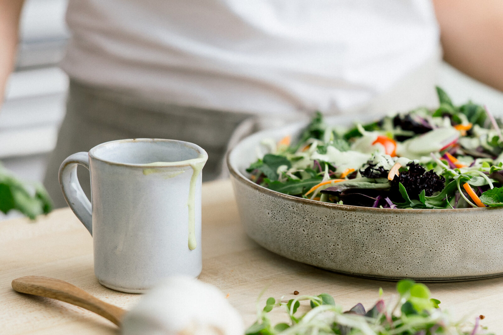 Detail photograph of a fresh salad bowl and ceramic mug created during a nutritionist branding photoshoot.